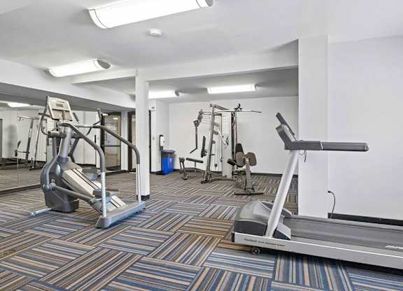 a gym with cardio equipment and weights in a building