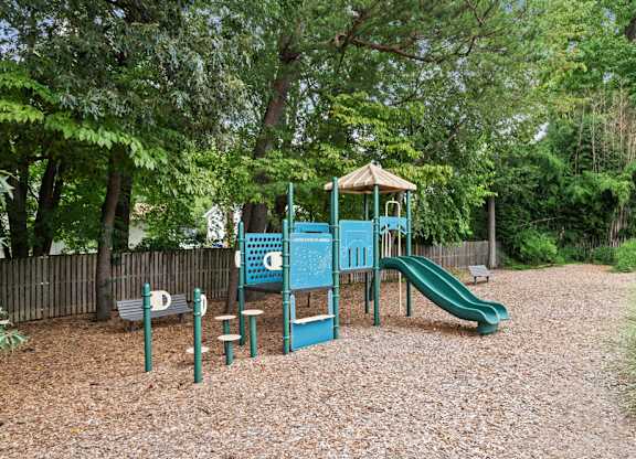A playground with a swing set and slides in a park