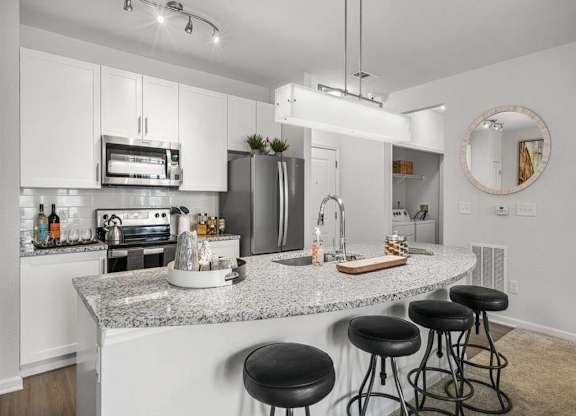a kitchen with an island with black stools