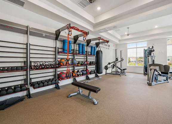 A well-equipped gym with a variety of exercise equipment and a bench.