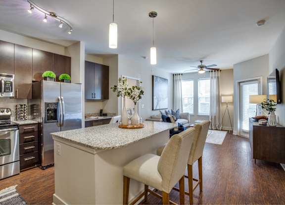 A modern kitchen with a center island and stainless steel appliances.