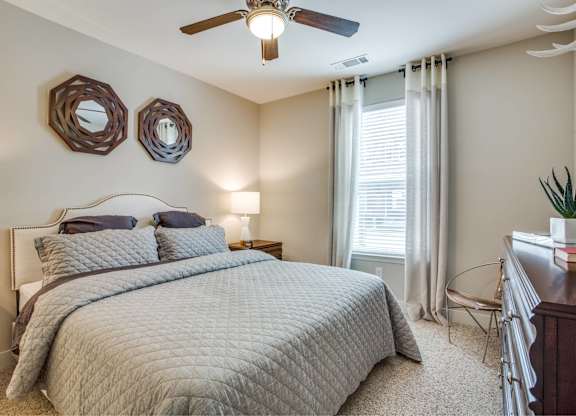 Large bedroom with carpet flooring, natural light, ceiling fan