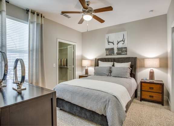 Large bedroom with carpet flooring, natural light, ceiling fan