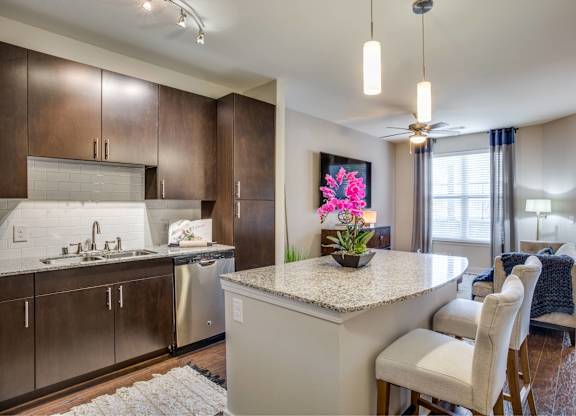 A kitchen with a sink, stove, and countertop.