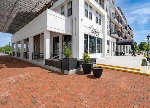 A white building with a red brick walkway in front.
