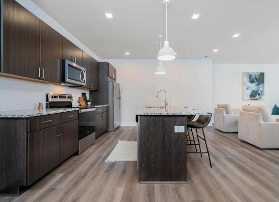 A modern kitchen with dark wood cabinets and a white countertop.