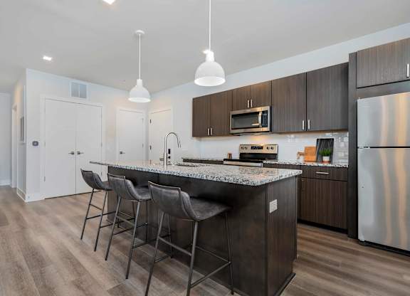 A kitchen with a granite countertop and stainless steel appliances.