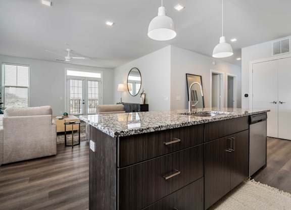 A modern kitchen with dark wood cabinets and a granite countertop.