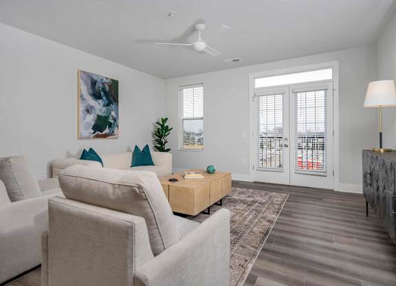 A living room with a large painting on the wall and a ceiling fan.