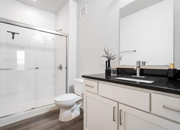 A white toilet sits in a bathroom next to a sink.