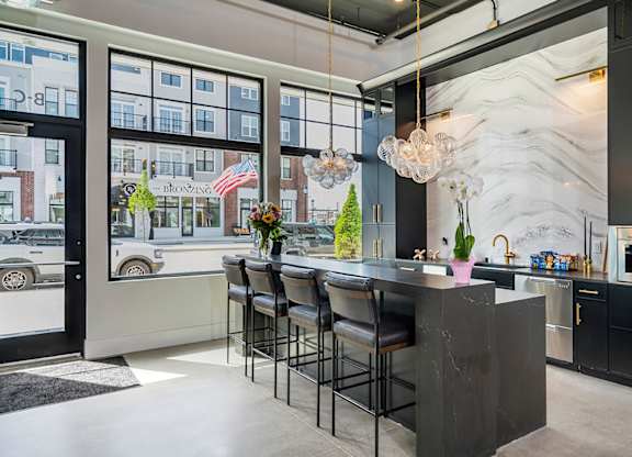 A kitchen with a marble backsplash and a bar area.