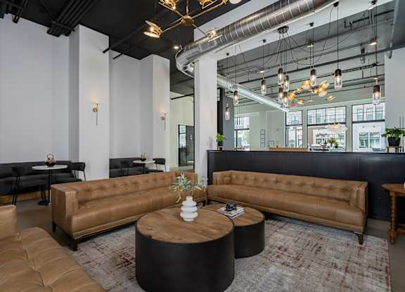 A modern living room with a brown leather sofa and a wooden coffee table.