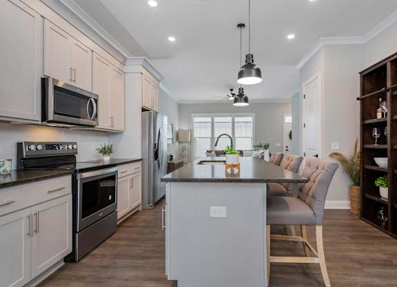 A modern kitchen with a center island and a dining area.