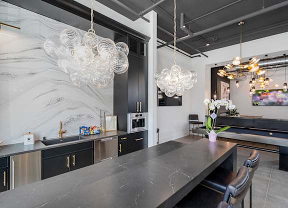 A modern kitchen with a marble backsplash and a pool table.