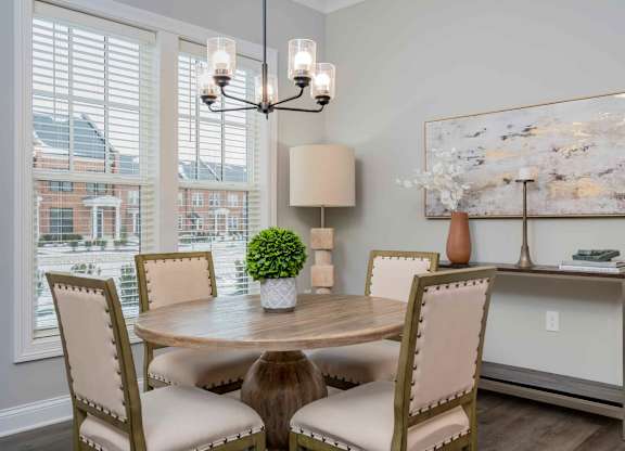 A dining room with a round table and chairs.