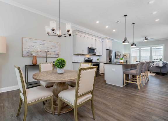 A modern dining room with a round table and chairs.