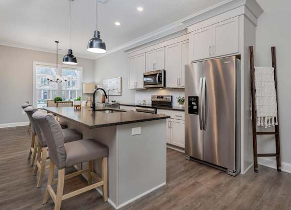 A modern kitchen with a large island and stainless steel appliances.