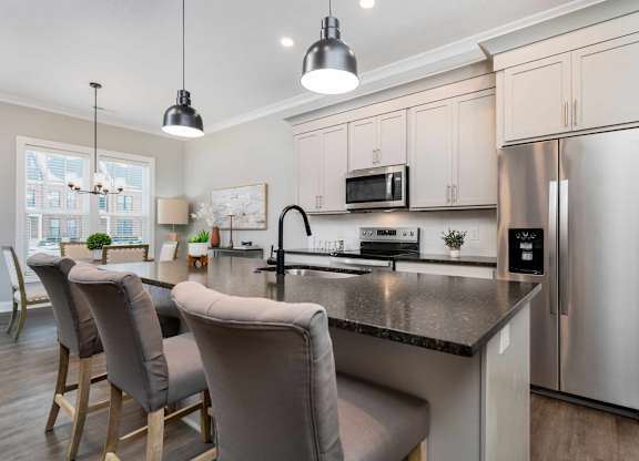 A modern kitchen with a large island and stainless steel appliances.