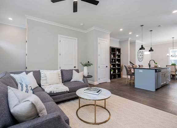 A living room with a grey couch and a round coffee table.