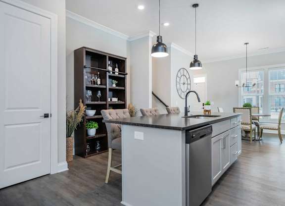 A modern kitchen with a large island and a dining area.