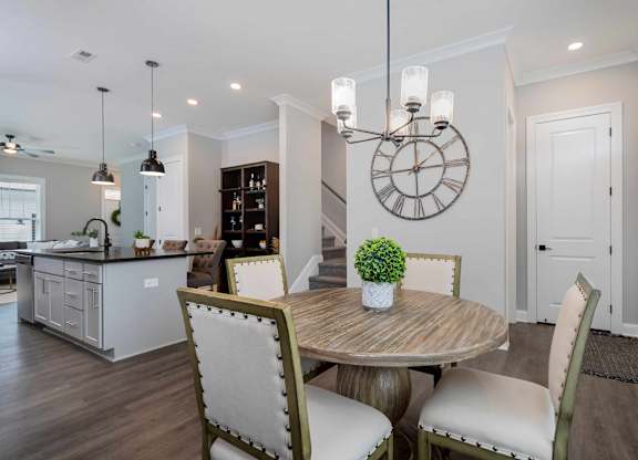 A dining room with a round table and chairs.