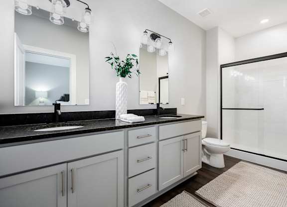 A bathroom with a sink, mirror, and toilet.