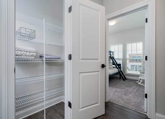 A white closet with shelves and towels.