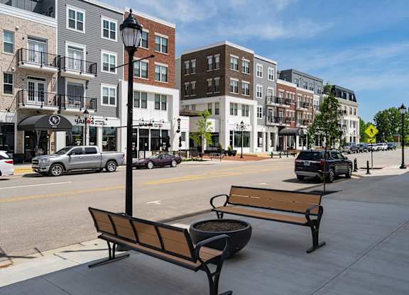 A city street with a bench and a lamp post.