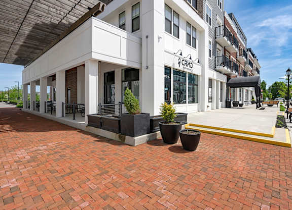 A white building with a black awning and a sign that says