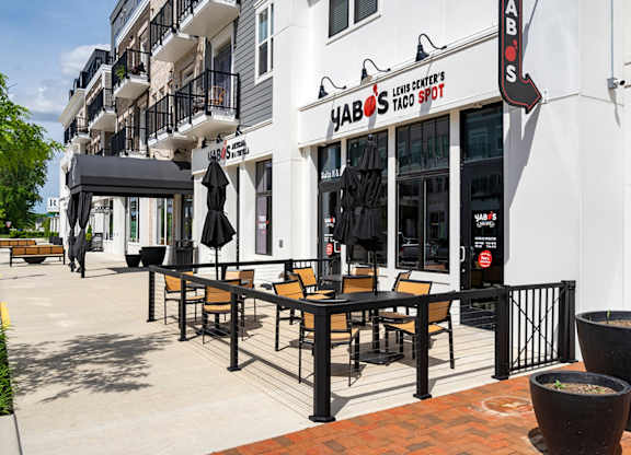 A restaurant named HABOS Taco Spot is located in a white building with black railings and a black awning.