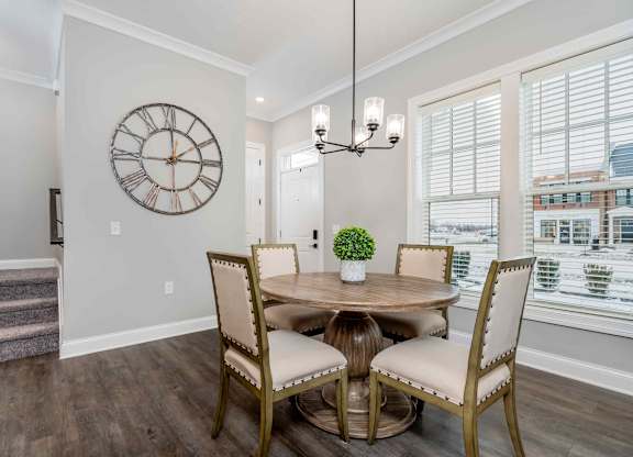 A dining room with a round table and chairs.