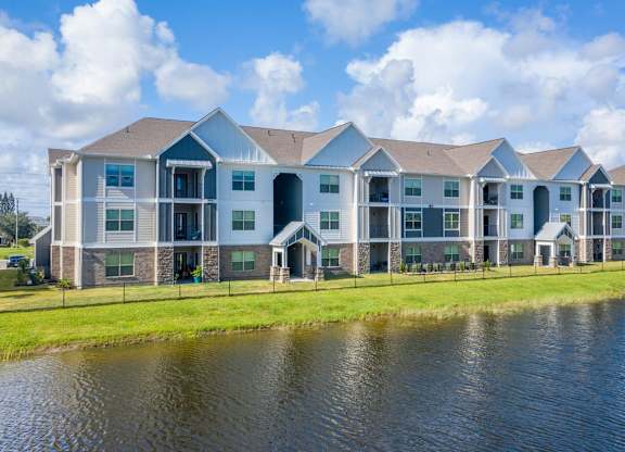 A large apartment complex with a pond in front at Mode at Melbourne, LLC Apartments, Melbourne, FL, 32901
