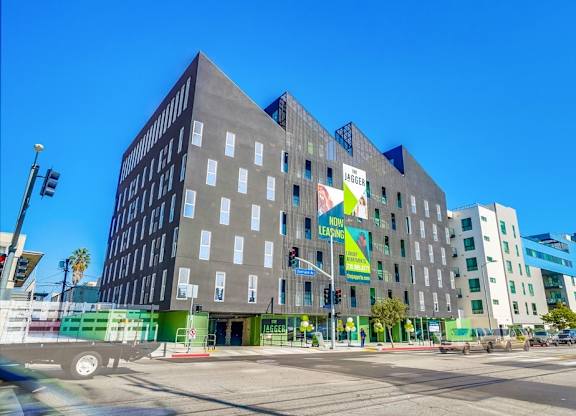 A large grey building with a green sign on the front.
