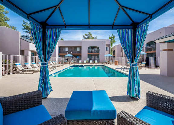 A pool area with blue furniture and a blue canopy.