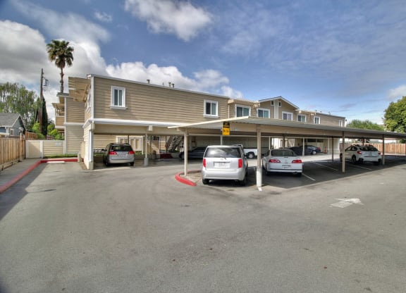 A parking lot with cars and a building in the background.