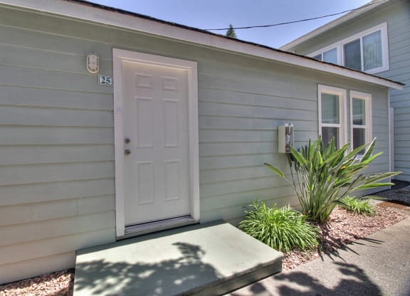 A small house with a white door and a small window on the side.