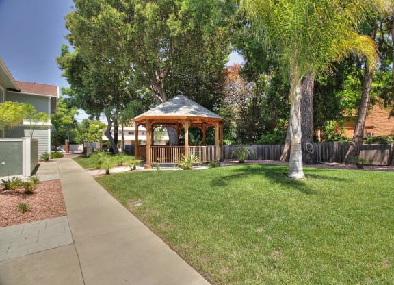 A gazebo is in the middle of a grassy area.