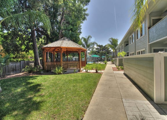 A gazebo is in the middle of a grassy area.