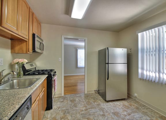 A kitchen with a granite counter top and a refrigerator.
