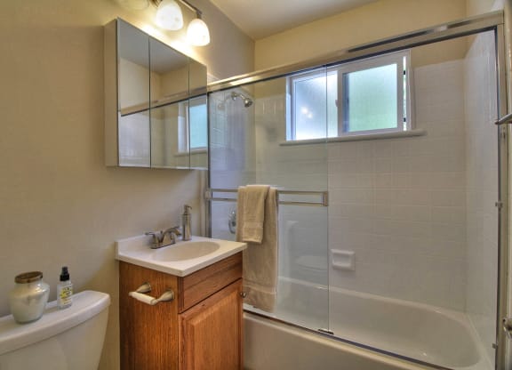 A bathroom with a white sink and a white tub.