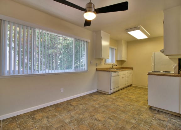 an empty kitchen with a large window and a sink