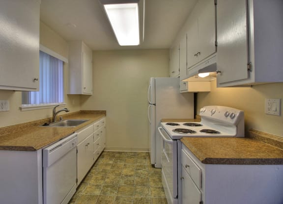 a kitchen with white appliances and granite counter tops