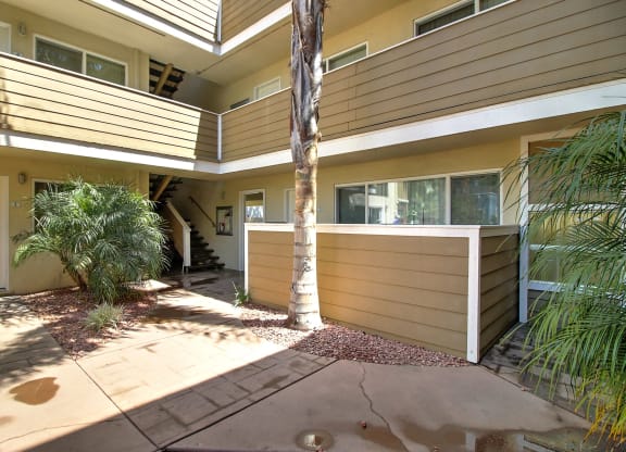a side view of the apartment with a palm tree in the front