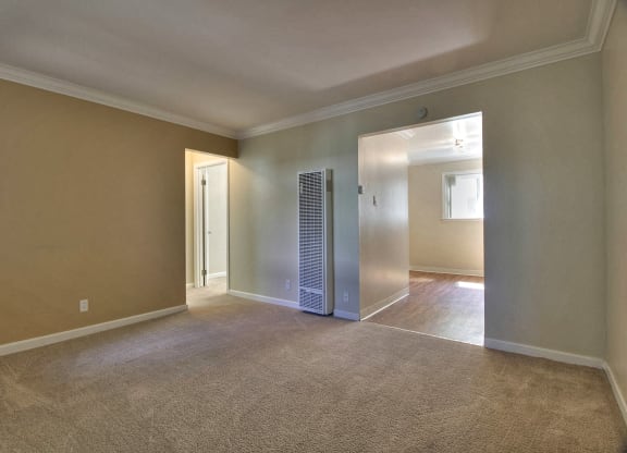 A room with a carpeted floor and a door leading to another room.