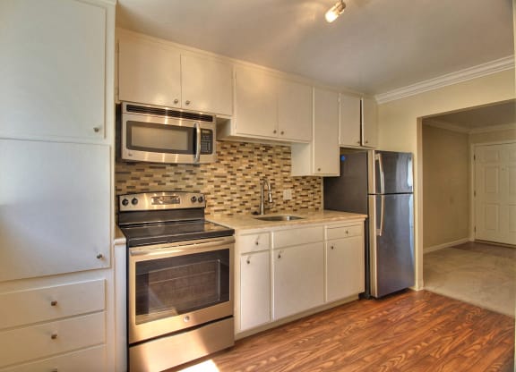 A kitchen with white cabinets and stainless steel appliances.