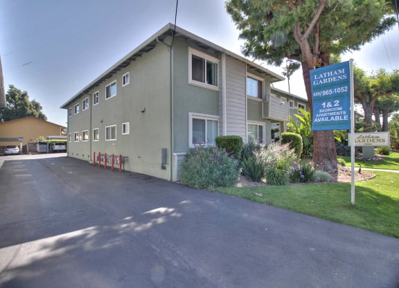 A street view of a residential area with a sign for Latellum Gardens.