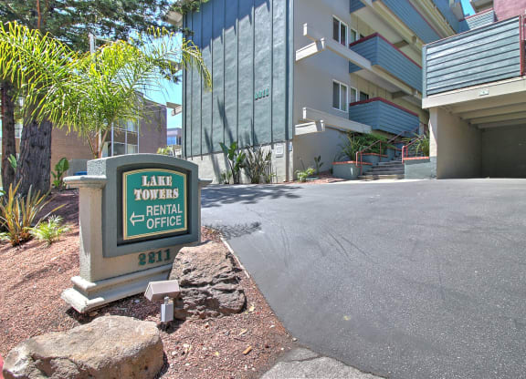 A sign for Lake Towers Rental Office is in front of a building.