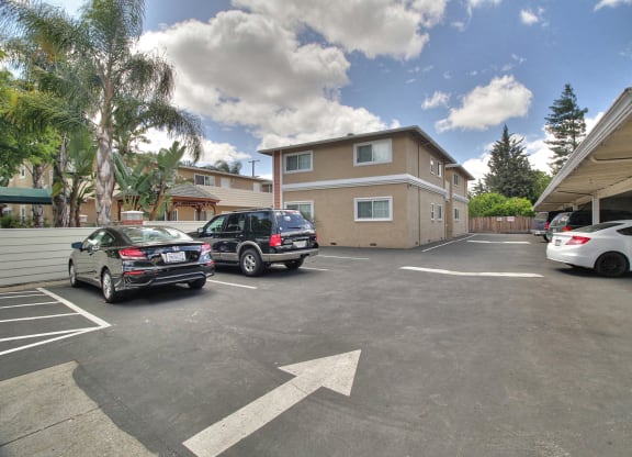 A parking lot with cars and a white arrow on the ground.