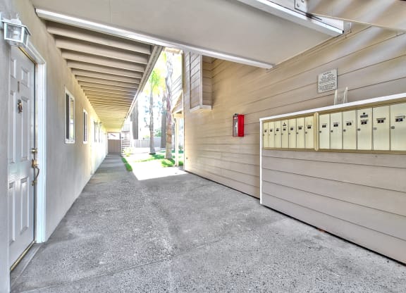 A long hallway with a red fire extinguisher mounted on the wall.