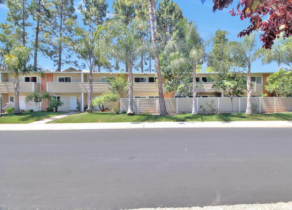 A row of houses with trees in front.
